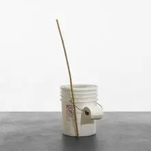 Jason Rhoades, Portable Toilet and Bamboo Stick/Pencil Set, 1993, plastic bucket, lid, bamboo stick, two polaroid photographs and paper instructions