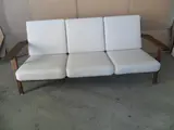AN OAK FRAMED PLANK SOFA, with white upholstered loose cushions by Hans J. Wegner, sold Jul 2012
