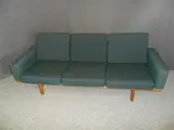 A GE-236 SOFA, with oak frame and teal upholstered loose cushions by Hans J. Wegner, sold Jul 2012