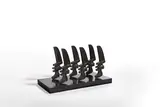 Elizabeth Strong-Cuevas, Running Heads, 1981, Bronze mit schwarzbrauner Patina, auf beschichtete Spanplatte montiert