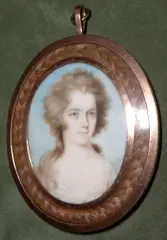 Thomas Hull, A Lady, wearing white dress with frilled neckline, her brown hair worn long, yellow metal oval frame with plaited hair border, the rear with double 'S' initials,