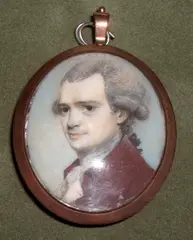 George Engleheart, A Gentleman, wearing plum-coloured coat over cream waistcoat and frilled white cravat, his powdered hair curled and worn en queue, yellow metal oval frame, the rear with blue silk,