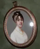 Robert Saunders, A Lady, wearing white dress, a cross pendant on a string of amber beads around her throat, her brown hair curled and upswept and dressed with strands of pearls., yellow oval metal frame with plaited hair border,