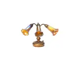 A Three-Light Lily Piano Lamp by Tiffany Studios, circa 1910, gilded bronze, the base cast with foliate detail, the Favrile glass shades in a golden and petrol blue iridescent glass, offered Aug 2020
