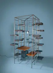 Gruppe Pentagon, Bibliothek – mit 66 Tablaren, Schreibtisch, Sitz und Schubladencontainer, 1988, Stahlblech, abgekantet; Stahlrechteckprofil, verschweißt / Schreibtisch und Sitz: Stahlblech, Holzplatte, lederbezogen; Container: Auszug rollengelagert; Beleuchtung