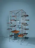 Gruppe Pentagon, Bibliothek – mit 66 Tablaren, Schreibtisch, Sitz und Schubladencontainer, 1988, Stahlblech, abgekantet; Stahlrechteckprofil, verschweißt / Schreibtisch und Sitz: Stahlblech, Holzplatte, lederbezogen; Container: Auszug rollengelagert; Beleuchtung