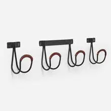 Wall hooks, set of three by Jacques Adnet, c. 1955, saddle-stitched leather over steel, sold Apr 2024