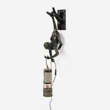 Blackman Cruz Workshop, Thieving Monkey, Left-Handed wall lamp, c. 2023, cast bronze with dark patina and polished gold highlights, glass, vintage electrified miner's lamp