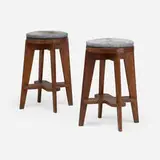High stools from the Scientific Block, Punjab University, Chandigarh, pair by Pierre Jeanneret, c. 1965-66, teak, hide upholstery, sold May 2026