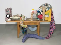 John Bock, 1 = 2 + KleinOdTot, 2000, Tisch, Textilien, Holz, Klebeband, Teekanne, Kissen, Rotweinflasche, 2 VHS Kassetten, Draht