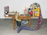 John Bock, 1 = 2 + KleinOdTot, 2000, Tisch, Textilien, Holz, Klebeband, Teekanne, Kissen, Rotweinflasche, 2 VHS Kassetten, Draht