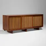 Special-order Triple Sliding Door cabinet by George Nakashima, 1976, American black walnut, pandanus cloth, sold Jan 2026