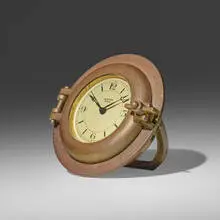Porthole table clock by Hermès, c. 1955, brass, glass, enameled aluminum, sold Mar 2024