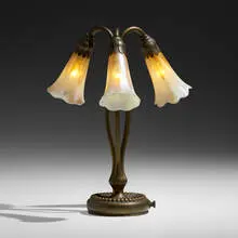 Three-light Lily table lamp by Tiffany Studios, c. 1910, patinated bronze, hand-blown Favrile glass, sold Sep 2022