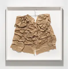 Herbert Zangs, Ohne Titel, aus der Serie „Objects“. 1970er-Jahre, Bleistift auf braunem, gefaltetem Packpapier, Heftklammern und Klebeband, am Metallkleiderbügel befestigt, im Objekt-Rahmen