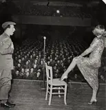 George Silk, Marlene Dietrich posing seductively as she exhibits her famous shapely leg while entertaining troops in Germany. 27. Februar 1945, Vintage. Silbergelatineabzug