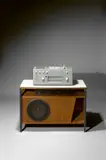 Phonogerät Studio 1 (Kompaktgerät RC62-5) in Grau mit Lautsprecherunterbau (L 3) von Gerhard Lander by Hans Gugelot und Herbert Lindinger, 1957, Metallgehäuse, lackiert; Kunststoff / Metallgestell; Nussbaum auf Tischlerplatte – Hersteller: Max Braun oHG, Frankfurt , sold May 2018