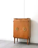 Illuminated Cocktail Cabinet by Laszlo Hoenig, circa 1961, walnut with yew inlay and applied gilt metal design, the interior in rosewood, sycamore and mirrored glass, sold Apr 2016