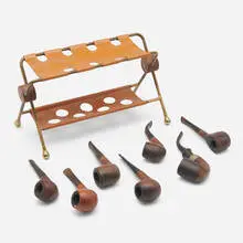 Collection of pipes and pipe rest by Henry P. Glass, c. 1955, brass, leather, walnut, carved wood, silver-plated brass, sold Aug 2023