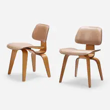 DCW, pair by Charles and Ray Eames, walnut plywood, leather, sold Jun 2023