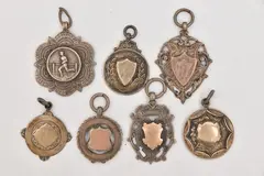 one with engraved rose metal cartouche, others have vacant cartouches, by Seven Silver Fob Medals, sculpture, sold Jan 2026
