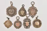 one with engraved rose metal cartouche, others have vacant cartouches, by Seven Silver Fob Medals, sculpture, sold Jan 2026