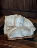 Bébé dormant les poings sur la poitrine by Jean-Joseph Carriès, Plâtre patiné, sold Jun 2025