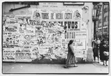 Scène de rue, femme passant devant un mur d’affiches, Colombie (Amérique du Sud). Circa 1958 by Jesse A. Fernández, Tirage argentique postérieur réalisé par le photographe (1978) sous passe-partout et encad, sold Nov 2025