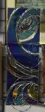 A stained glass collage with wire swirls on a mirrored by Sharon Baldry, mixed media, offered Oct 2024