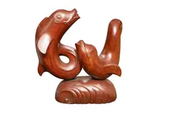 A carved wood sculpture of two dolphins by Donald Potter, sculpture, offered Feb 2026