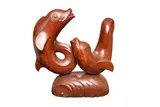 A carved wood sculpture of two dolphins by Donald Potter, sculpture, offered Feb 2026