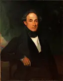 Portrait of Pompeo Anichini, half length, seated, wearing a dark suit, before a window by English School, oil on canvas, sold Dec 2014