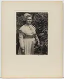 SHAKER WOMAN IN GARDEN PHOTOGRAPHIC PORTRAIT by Doris Ulmann, platinum print depicting a standing woman in dress and bonnet, sold Jun 2024