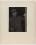 NEW ENGLAND MAN PHOTOGRAPHIC PORTRAIT, platinum print depicting a standing man wearing all dark clothing and holding a pipe in right hand by Doris Ulmann, pencil signature ", sold Jun 2024