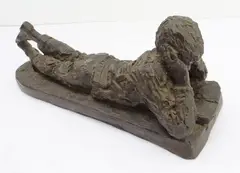 Boy reclining and reading by Karin Jonzen, sculpture, offered Aug 2023