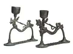Bali by Two Lamps, bronze, each with a cup-shaped container for oil rising from a curved supporting frame ending in two legs attached to a, sold Oct 2013