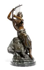 An early 20th century bronze figure of a bare breasted Nubian, seated on a Pharaoh mask playing a harp by Georges Charles Coudray, bronze, sold Jan 2018