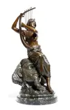 An early 20th century bronze figure of a bare breasted Nubian, seated on a Pharaoh mask playing a harp by Georges Charles Coudray, bronze, sold Jan 2018