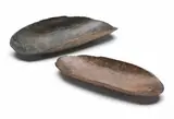 A Pair Of Small Coolamons by Artefacts And Carvings, both with incised linear adze markings and old shiny patina, sold Oct 2009