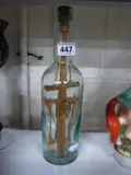 a wooden crucifix sculpture in a glass bottle, cork inscribed 'Capt Hickmet of Flannally 1897 by Boer War Interest, sculpture, sold Jan 2016