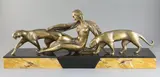 An Art Deco bronze group of a reclining woman with two panthers, on signed two colour marble plinth, 22.75in by Michel Decoux, bronze, offered Oct 2019