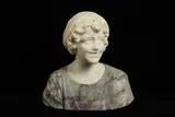 AN ALABASTER BUST OF A GIRL, the smiling young maiden wearing a headdress and a dress embroidered with flowers carved in coloured alabaster by Prof Giachi, sculpture, offered Mar 2021