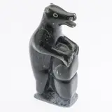 Standing Bear by Qaunaq Palluq, 1990, carved stone depicting a standing bear leaning on a rock, offered Jun 2024
