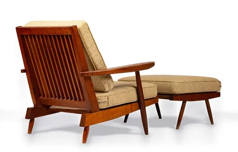 Cushion Arm Chair and Ottoman by George Nakashima, circa 1967, American black walnut with plywood seat platforms and oatmeal wool tweed upholstery, sold Sep 2026