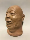 Masque du gros compradore riant by Gaston Hauchecorne, Epreuve en terre cuite, sold Apr 2019