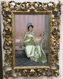 Lady in lime silk dress seated on a canape, a sprig of flowers in her right hand, in blue ribboned and feathered bonnet” oil on canvas by Vittorio Reggianini, oil on canvas, offered Dec 2024