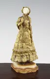 A gilt bronze and ivory figure of a lady wearing a bonnet, on brown onyx base by René Paul Marquet, bronze and ivory, sold Dec 2015