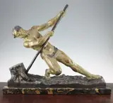 An Art Deco patinated metal figure of a man working a tree stump, marked Ouline, on a rectangular marble base, 21.25in by Alexandre Ouline, sculpture, sold Apr 2015