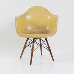Armlehnstuhl 'PAW' auf 'dowel-legged wood and wire base with swivel' by Charles and Ray Eames, 1950, Fiberglasverstärkter Kunststoff, zitronengelb, Metallstäbe, Metallblech, schwarz lackiert, Holz (Seng, Chicago (Fuß- und, sold Oct 2026