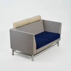Zweisitzersofa aus der 'Eastside Collection' by Ettore Sottsass, 1982, Satinierter Stahl mit transparenten Kunststofffüßen, Holzrahmen, Schaumstoffpolsterung, Wollbezug, blau, grau und vanill, sold Jun 2026